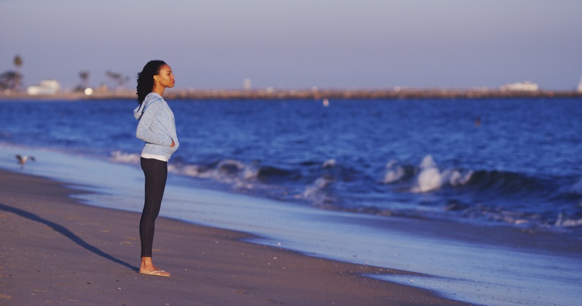 Black woman enjoying the ocean view until waves come